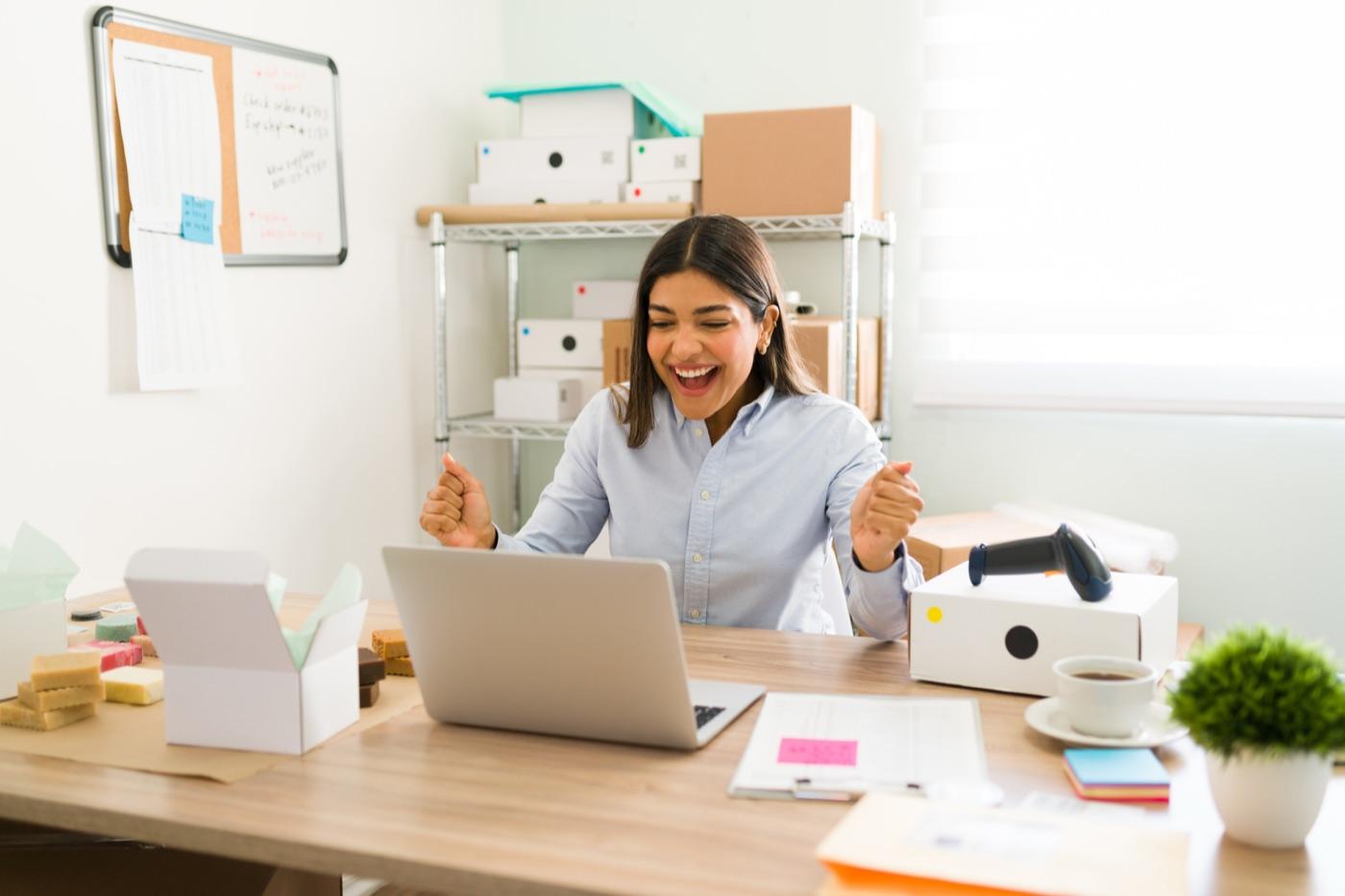 Marketer celebrating successful campaign results at her desk