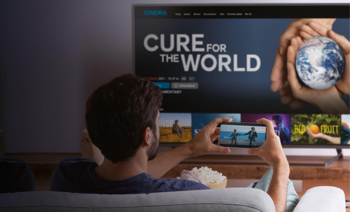 Person watching Connected TV while holding a phone