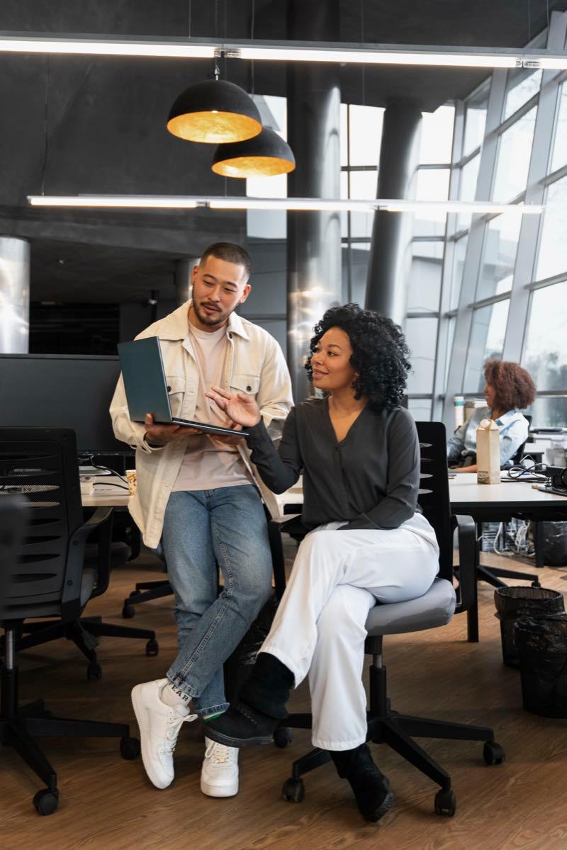 Two colleagues reviewing media plans in a modern office